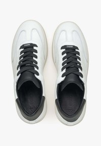 Witte leren sneakers met een zwarte leren kraag, voorzien van zwarte veters en een logo op de tong. Gladde textuur met een ronde tekening.