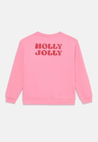Sweatshirt rosa com o texto "HOLLY JOLLY" em letras vermelhas em negrito. Material de algodão suave com punhos e bainha canelados, design de gola redonda.