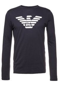 Långärmad skjorta i marinblått av bomull med en distinkt vit randig örnlogotyp och "GA" i mitten. Slät textur.