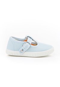 Zapato de lona azul claro con punta redondeada, correa cruzando el empeine y suela de goma blanca. Presenta un acento decorativo de botón en la correa.