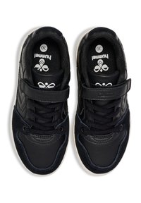 Zapatillas negras con un upper de cuero suave y acentos de ante contrastantes. Presenta una correa de Velcro y una suela texturizada. Etiqueta de tamaño visible en el interior.