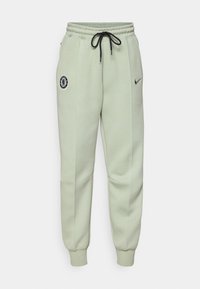Lysegrøn Nike joggebukse med elastisk midje, snor, sidelommer og Chelsea FC-logo på venstre lår.