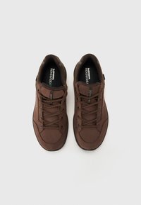 Bruine wandelschoenen met een gladde bovenkant, voorzien van ronde veters, een verstevigde neus en een gevoerde inlegzool voor comfort.