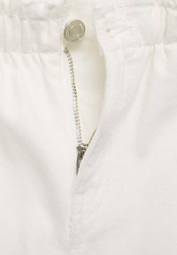 Tessuto bianco con apertura a zip, zip in metallo con linguetta, e bottone a pressione argentato in vita. Texture liscia, senza pattern visibili.