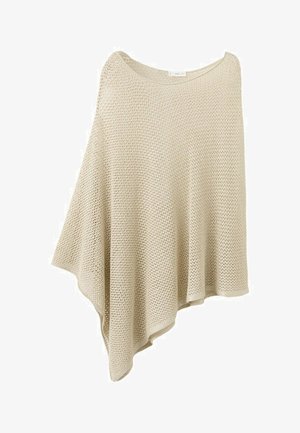 Poncho beige en tricot avec un ourlet asymétrique et un motif en maille ajourée, conçu pour une coupe ample et drapée.