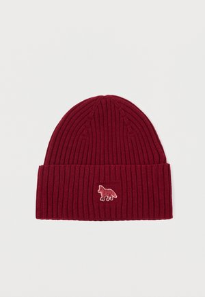 Beanie en tricot côtelé bordeaux avec un revers et un petit logo de renard brodé dans une couleur contrastante. Texture douce, design ajusté.