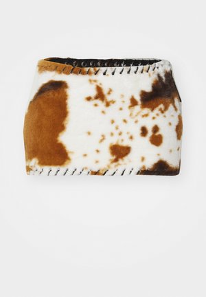 Tessuto a motivo di pelle di mucca marrone e bianco con una texture morbida, rifinito con dettagli in pizzo nero lungo i bordi.