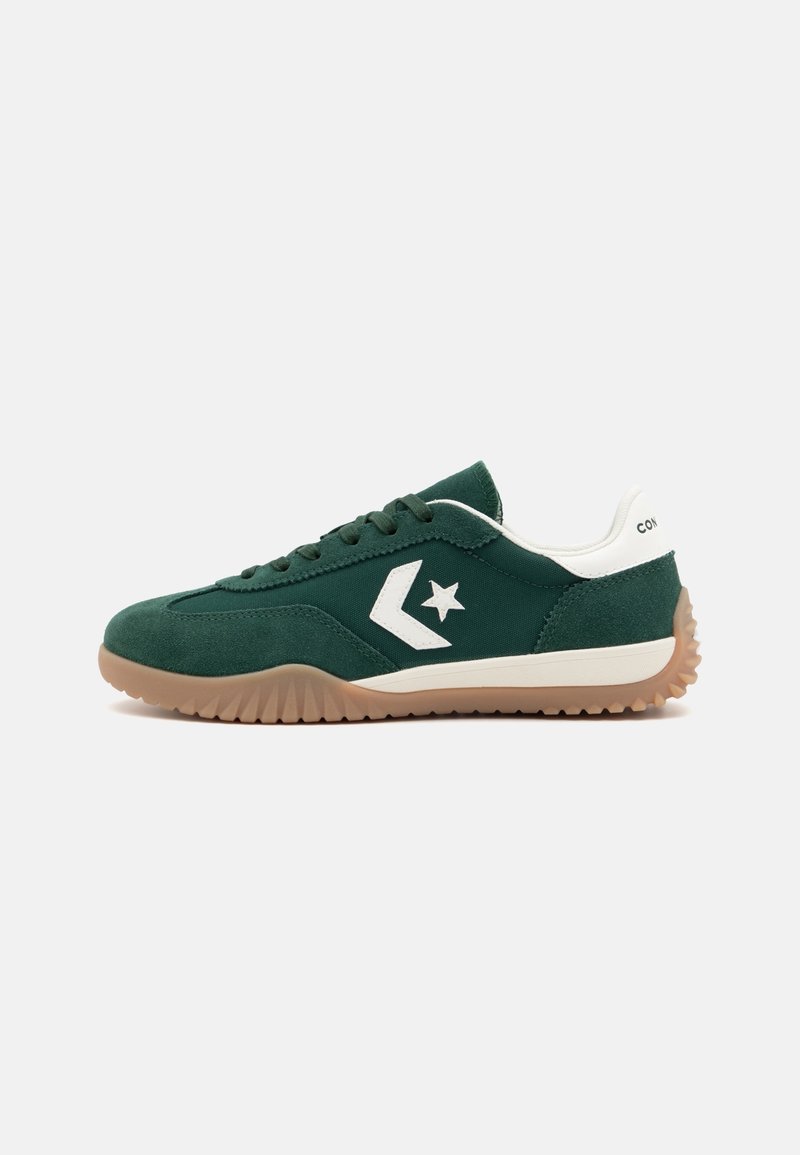 Zielone zamszowe sneakersy z białym logo gwiazdy, teksturowaną gumową podeszwą i kontrastującymi białymi akcentami na pięcie i języku. Sznurowany design.