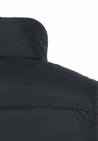 Schwarze Pufferjacke mit hohem Kragen, glatter Textur und dezenten Nähten über den Schultern. Entworfen für Wärme und Komfort.