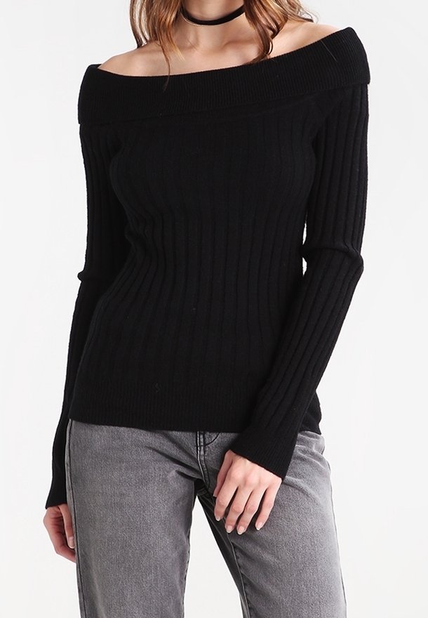 Schwarzer schulterfreier Rippstrickpullover mit langen Ärmeln, figurbetontem Design und weicher Textur. Kombiniert mit grauen Jeans.