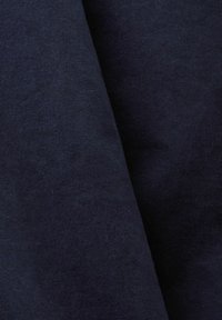 Tumši jūras zilas audums ar gludu tekstūru, kam ir neliels spīdums un tīrs, vienmērīgs austa raksts.