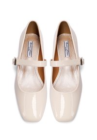 Scarpe Mary Jane in pelle sintetica beige chiaro con punteton tondo, tacco piatto e cinturino regolabile sullo scarpone. Fodera argentata visibile all'interno.