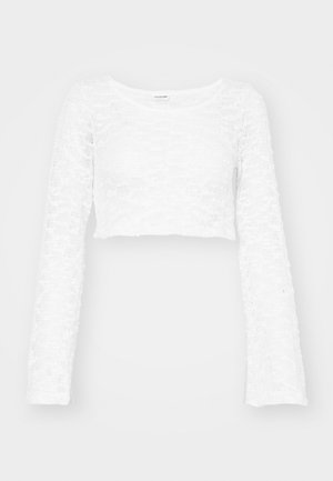 Top bianco a maniche lunghe cropped realizzato in pizzo testurizzato, con scollo rotondo e polsini a campana, che creano un motivo a trama aperta.