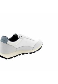 Scarpa sportiva bianca con materiale in rete, forma arrotondata, design con lacci e suola in gomma scura con motivi di trazione. Accento grigio sul tallone.