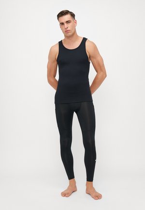 Juodas medvilnės tank top'as derinamas su juodais prigludusiais leggingais, pagamintais iš lygaus, elastingo audinio. Savybės - apvalus iškirpimas ir jokie matomi logotipai.