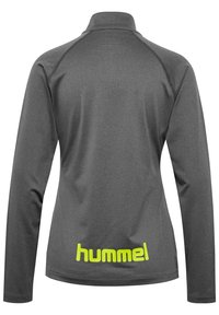 Szary, długi top z długim rękawem i wysokim kołnierzem. Posiada teksturowaną tkaninę oraz jasnosłoneczną żółtą logo "hummel" na dolnej części pleców.
