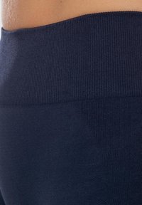 Námořnické legíny s vysokým pasem, vybavené ribbovaným pasem a hladkým povrchem, se subtilním vzorem pro přidaný detail.