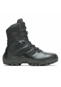 Czarne taktyczne buty wykonane z skóry i syntetycznych materiałów, charakteryzujące się wysokim krojem, solidnymi sznurowadłami oraz wytrzymałą podeszwą z bieżnikiem.