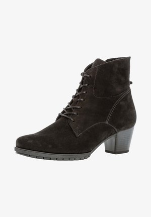 Stivale alla caviglia in suede nero con punta affilata, chiusura con lacci e tacco a blocco moderato. Parte superiore testurizzata e suola in gomma con scanalature di trazione.
