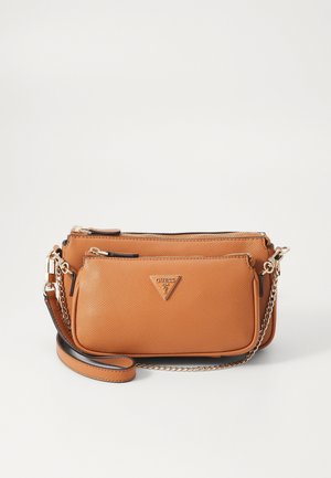 Pochette en cuir marron texturé avec bandoulière chaîne dorée et fermetures éclair, avec une plaque logo Guess triangulaire sur la poche avant.