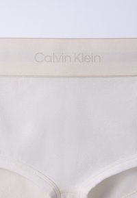 Άσπρα ανδρικά εσώρουχα Calvin Klein με ριμπ ύφασμα και πλατιά ελαστική ζώνη μέσης με το όνομα της μάρκας σε διακριτικά μπεζ γράμματα.