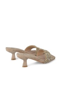 Mules beige con tacco alto, dotati di una larga fascia decorata con strass trasparenti, caratterizzati da un tacco a blocco leggermente curvato e una morbida texture in suede.