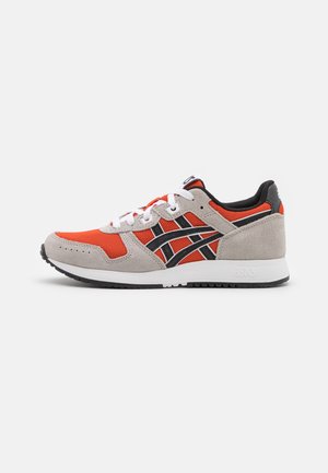 Lavt sneakers med orange mesh, grå ruskindsoverlejringer, sorte striber, hvide snørebånd og hvid sål på hvid baggrund.