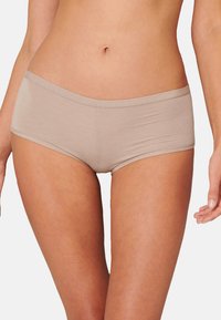 Beige hipster-shorts valmistettu sileästä kankaasta, jossa on joustava vyötärö. Muotoilu sisältää saumattoman viimeistelyn ja napakan istuvuuden.