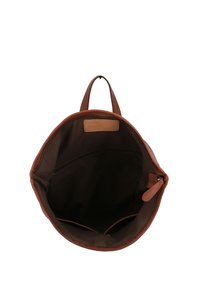 Brązowa skórzana torba o okrągłym kształcie. Posiada ciemne wnętrze z tkaniny, kieszeń na zamek oraz beżową łatkę wewnątrz. Minimalna ilość elementów metalowych.