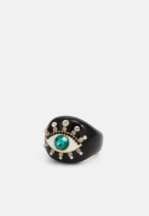 Black ring featuring an eye design with a central green gem and surrounding clear crystals on a white background.