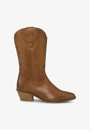 Kožená kovbojská čižma svetlohnedej farby po stred lýtok s dekoratívnym prešívaním, špicatou špičkou a nízkym vrstveným podpätkom na bielom pozadí.