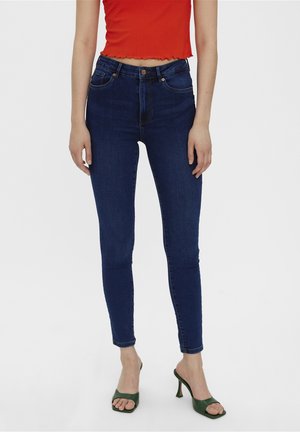 Tmavě modré skinny džíny s vysokým pasem mají pružnou denimbou, pět kapes a zip s knoflíkovým zapínáním.