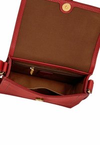 Sac à main en cuir rouge avec une texture lisse, doté d'un intérieur en tissu marron, d'une poche zippée et d'une fermeture à bouton-pression doré.