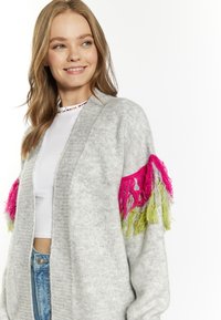 Cardigan grigio lavorato a maglia con vivaci frange rosa e verdi sulle maniche, design aperto davanti e vestibilità casual.