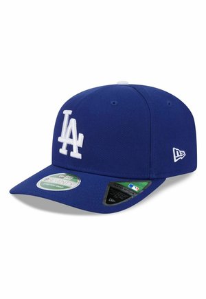 Blauwe honkbalpet met wit "LA"-logo aan de voorkant, New Era-logo aan de zijkant en twee stickers op de klep tegen een witte achtergrond.