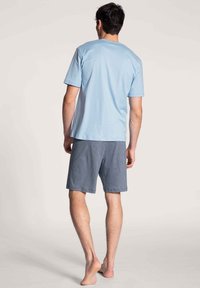 Lichtblauw T-shirt met korte mouwen, gecombineerd met marineblauwe geruite shorts, gemaakt van zachte stof, met een relaxte fit en een elastische tailleband.