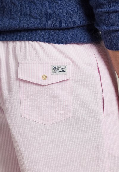 Šviesiai rožiniai šortai su tekstūruota, languota raštą. Turi užpakalinį kišenę su mygtuko uždarymu ir etiketę kišenės krašte.