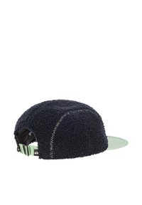 Cappello blu navy con texture in pile, visiera curva e cinturino regolabile. Accenti verdi sulla parte inferiore della visiera e del cinturino.