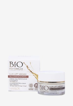 Vasetto di crema viso illuminante con base trasparente e coperchio bianco, accompagnato da una scatola bianca con dettagli in oro e informazioni sul prodotto.