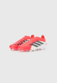 Φωτεινά κόκκινα και λευκά παπούτσια με μαύρες και γκρι ρίγες, χωρίς κορδόνια και με καρφιά στη σόλα για ποδόσφαιρο.