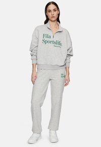 Grijze fleece sweatshirt met halve rits en grote groene tekst; bijpassende grijze sweatpants met groen logo; katoenmengsel, relaxte pasvorm.