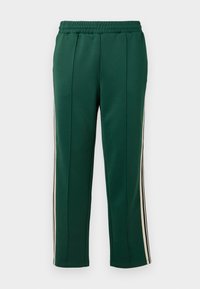 Pantaloni sportivi verzi cu talie elastică, două dungi laterale în alb și negru, și un croi conic cu o textură netedă.