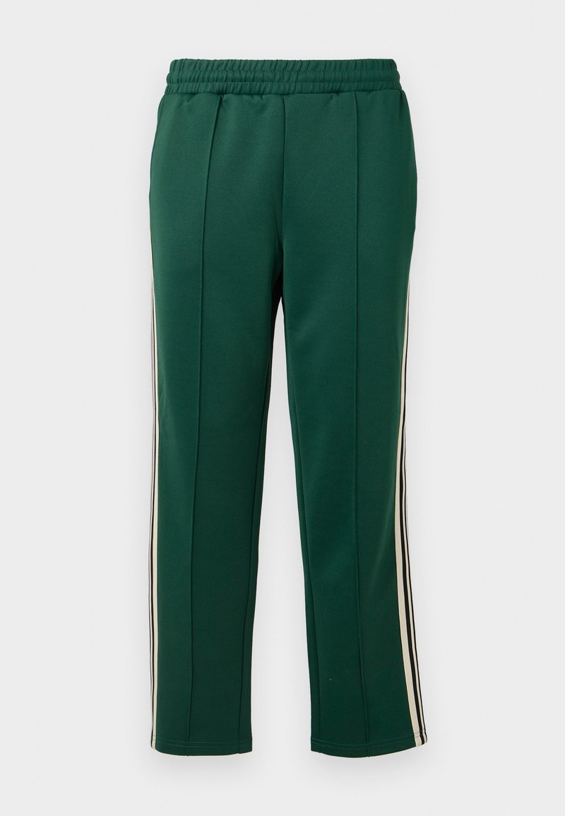 Pantalons de sport verts avec une taille élastique, deux bandes latérales blanches et noires, et une coupe fuselée avec une texture lisse.