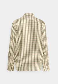 Camicia a quadri in beige e verde oliva con colletto classico, maniche lunghe e polsini con bottoni, caratterizzata da un motivo a griglia e una vestibilità rilassata.