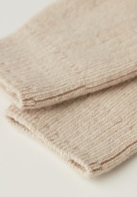 Beige strikkede fingerløse handsker med et tekstureret mønster og en blød uldblanding, med rå kanter og en tætsiddende pasform.