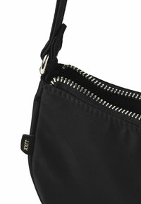 Zwarte nylon schoudertas met zilveren ritsen, een gestructureerd oppervlak en een afneembare band met een knoopdetail.