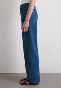 Blauwe denim wijduitlopende jeans met een gemiddelde taillehoogte, voorzien van een klassieke vijf-pocketontwerp en een schone afwerking zonder zichtbare slijtage.