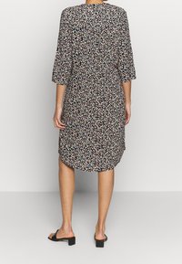 Svart blommig klänning med trekvartsärmar, knä-längd, mjukt tyg, med ett flerfärgat blommönster och en rundad nederkant.