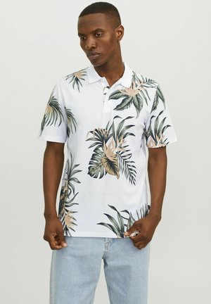 Kortärmad polo i vit tyg med ett tropiskt blad- och ananasmönster i gröna och beige nyanser; klassisk krage.