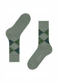 Un paio di calzini verde chiaro con un motivo argyle verde scuro e grigio e un piccolo bottone argento di dettaglio sul lato.
